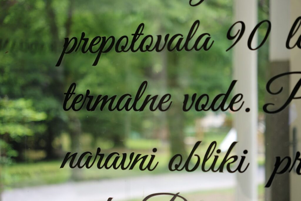 Napis o termalni vodi na steklu pitnika v Termah Dobrna