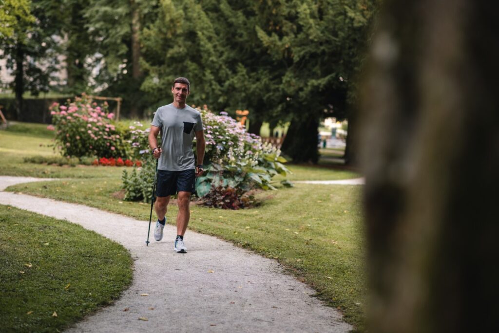 Moški med nordijsko hojo po poti v Zdraviliškem parku Term Dobrna